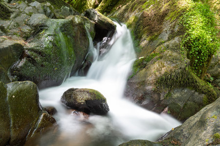 Long exposure of a waterfall on the Hoar Oak Water river flowing through the woods at Watersmeet in...