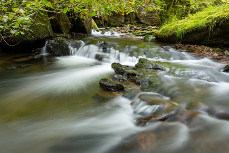 Long exposure of a waterfall on the Hoar Oak Water river at Watersmeet in Exmoor National Parkの写真素材