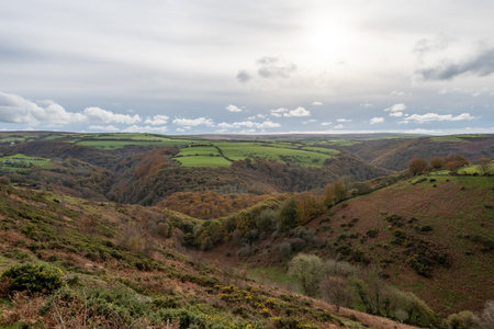 View from the top of Countisbury Hill of the autumn colours at Watersmeet Valley in Exmoor National...