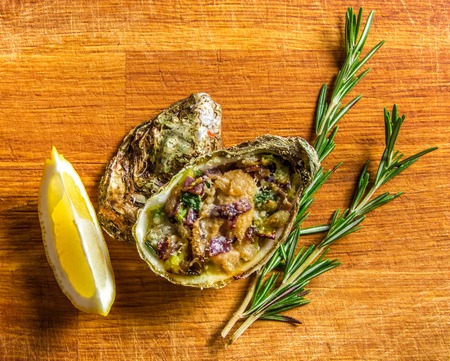 Salad in oyster served with greens and lemon on a wooden backgroundの写真素材