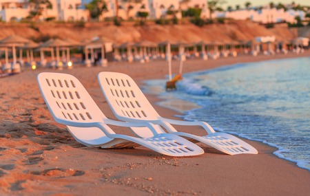 Landscape of Two Lonely beachchairs near sea and beautiful sunrise in the morning at a perfect beach...
