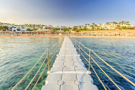 Pontoon with handrails through coral reef to the sea on tropical beach resort. Relaxing in the red sea, Egyptの写真素材