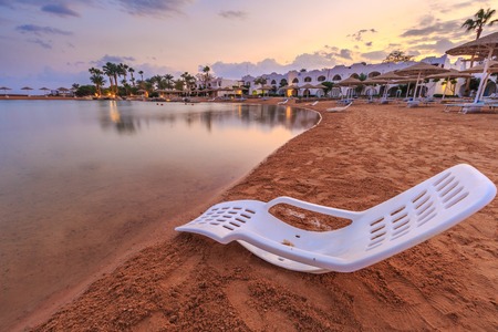 Landscape of lonely beachchair near sea and beautiful sunset in the evening at a perfect beach in Egyptの写真素材