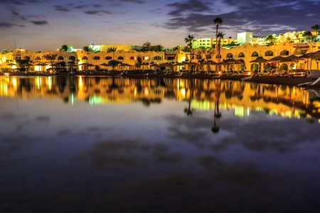 Evening view from sea which reflects the dark sky, for luxury hotel in night illumination on a beautiful resort in Egyptの写真素材