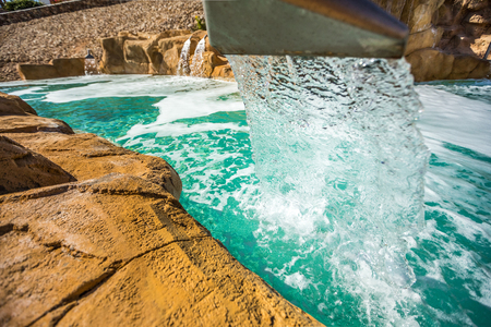 Stream of water out of artificial waterfall in outdoor pool at the luxury hotel in Egyptの写真素材