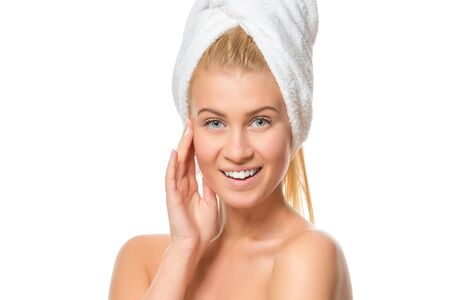 Young attractive blond woman with blue eyes in a towel  smiling  looking at the camera isolated on white background. Close up.の写真素材