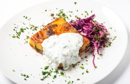 Piece of meat pie with vegetable and a garnish of red cabbage on a white plate. Close-upの写真素材
