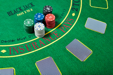 Casino chips and deck of cards lying on green casino table, poker game concept, top view.の写真素材
