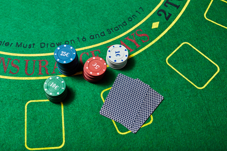 Casino chips and deck of cards lying on green casino table, poker game concept, top view.の写真素材