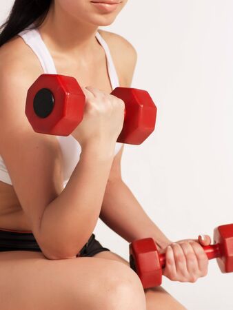 Young beautiful sportswoman doing fitness exercise with dumbbells, at studio shot. Health, beauty and fitness concept.の写真素材