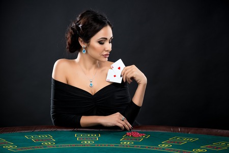 sexy woman with poker cards and chips. Female player in a beautiful black dressの写真素材