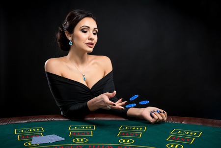 sexy woman with poker cards and chips. Female player in a beautiful black dressの写真素材
