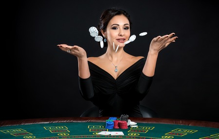 sexy woman with poker cards and chips. Female player in a beautiful black dressの写真素材