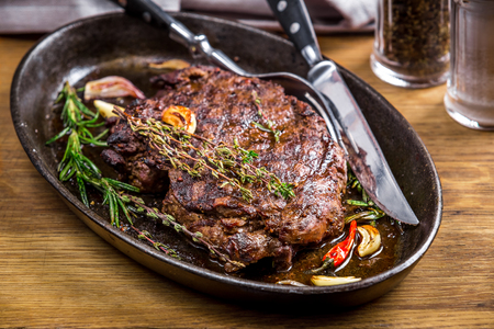 Healthy lean grilled medium-rare steak and vegetables with  whiskey glass and a spice in a rustic pub or tavern. Food-stylingの写真素材