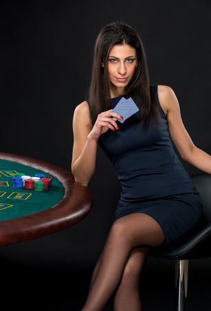 sexy woman with poker cards and chips. Female player in a beautiful black dressの写真素材