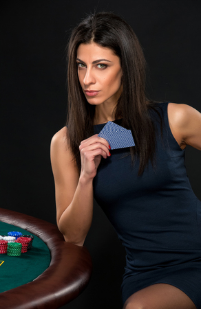 sexy woman with poker cards and chips. Female player in a beautiful black dressの写真素材