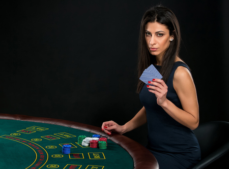 sexy woman with poker cards and chips. Female player in a beautiful black dressの写真素材