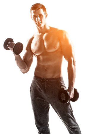 Handsome muscular man doing exercises with dumbbells isolated on white background Whith solar flareの写真素材