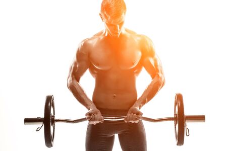 Young handsome man with naked torso and barbell isolated on white background Whith solar flareの写真素材