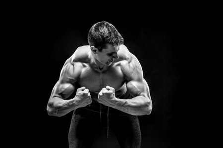 Fitness man model torso posing and showing perfect body, shoulders, biceps, triceps and chest on black background. Black and whiteの写真素材