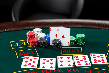 Poker play. Chips and cards on the green table