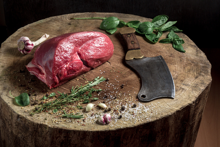 a juicy piece of meat lying on a wooden board with a butcher knife. Flavored with spicesの写真素材