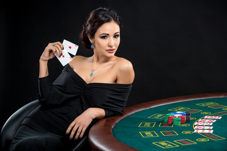sexy woman with poker cards and chips. Female player in a beautiful black dressの写真素材