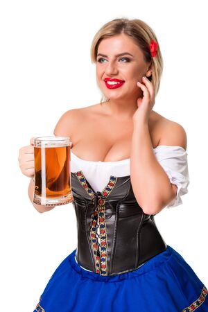 Beautiful young blond girl in dirndl drinks out of oktoberfest beer stein. Isolated on white background.の写真素材