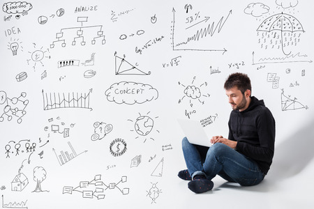 a young man in casual clothes working on a laptop. conceptの写真素材