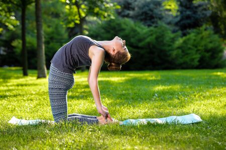 Young fitness woman meditation in a city park.Yoga at sunset in the park. Girl is practicing yoga. Fitness training outdoors. Attractive fitness woman. Workout outdoors. Healthy lifestyleの写真素材