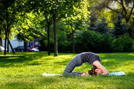 Young fitness woman meditation in a city park.Yoga at sunset in the park. Girl is practicing yoga. Fitness training outdoors. Attractive fitness woman. Workout outdoors. Healthy lifestyleの写真素材