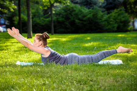 Young fitness woman meditation in a city park.Yoga at sunset in the park. Girl is practicing yoga. Fitness training outdoors. Attractive fitness woman. Workout outdoors. Healthy lifestyleの写真素材