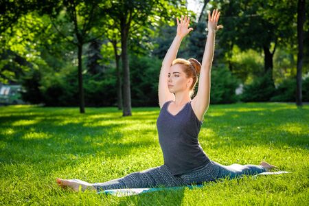 Young fitness woman meditation in a city park.Yoga at sunset in the park. Girl is practicing yoga. Fitness training outdoors. Attractive fitness woman. Workout outdoors. Healthy lifestyleの写真素材