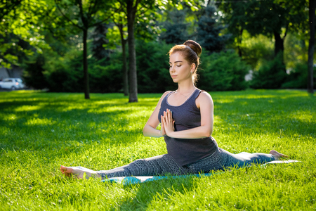 Young fitness woman meditation in a city park.Yoga at sunset in the park. Girl is practicing yoga. Fitness training outdoors. Attractive fitness woman. Workout outdoors. Healthy lifestyleの写真素材