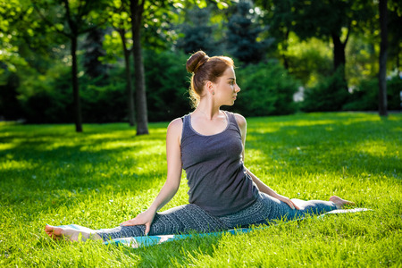 Young fitness woman meditation in a city park.Yoga at sunset in the park. Girl is practicing yoga. Fitness training outdoors. Attractive fitness woman. Workout outdoors. Healthy lifestyleの写真素材