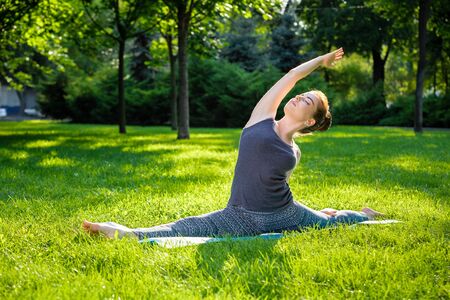 Young fitness woman meditation in a city park.Yoga at sunset in the park. Girl is practicing yoga. Fitness training outdoors. Attractive fitness woman. Workout outdoors. Healthy lifestyleの写真素材