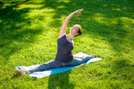 Young fitness woman meditation in a city park.Yoga at sunset in the park. Girl is practicing yoga. Fitness training outdoors. Attractive fitness woman. Workout outdoors. Healthy lifestyleの写真素材