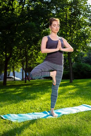 Young fitness woman meditation in a city park.Yoga at sunset in the park. Girl is practicing yoga. Fitness training outdoors. Attractive fitness woman. Workout outdoors. Healthy lifestyleの写真素材