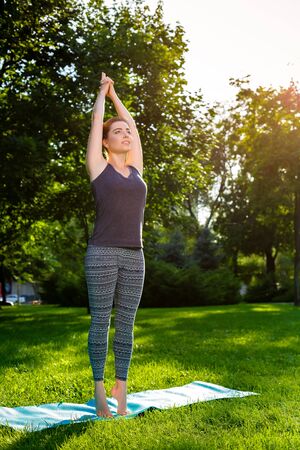 Young fitness woman meditation in a city park.Yoga at sunset in the park. Girl is practicing yoga. Fitness training outdoors. Attractive fitness woman. Workout outdoors. Healthy lifestyleの写真素材