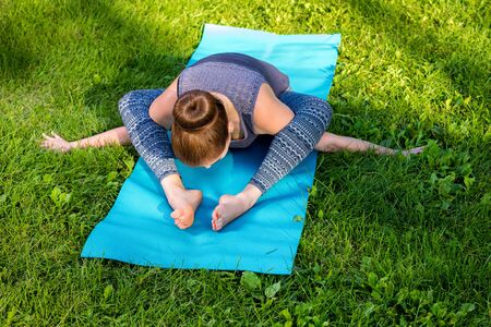 Young fitness woman meditation in a city park.Yoga at sunset in the park. Girl is practicing yoga. Fitness training outdoors. Attractive fitness woman. Workout outdoors. Healthy lifestyleの写真素材
