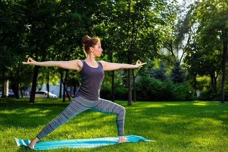 Young fitness woman meditation in a city park.Yoga at sunset in the park. Girl is practicing yoga. Fitness training outdoors. Attractive fitness woman. Workout outdoors. Healthy lifestyleの写真素材