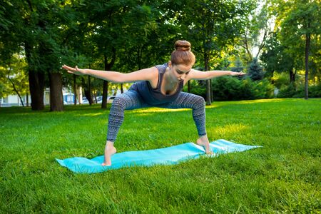 Young fitness woman meditation in a city park.Yoga at sunset in the park. Girl is practicing yoga. Fitness training outdoors. Attractive fitness woman. Workout outdoors. Healthy lifestyleの写真素材