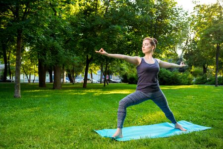 Young fitness woman meditation in a city park.Yoga at sunset in the park. Girl is practicing yoga. Fitness training outdoors. Attractive fitness woman. Workout outdoors. Healthy lifestyleの写真素材
