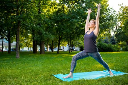 Young fitness woman meditation in a city park.Yoga at sunset in the park. Girl is practicing yoga. Fitness training outdoors. Attractive fitness woman. Workout outdoors. Healthy lifestyleの写真素材