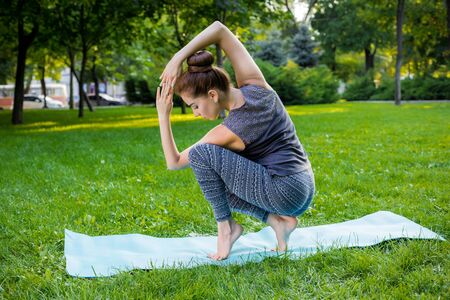 Young fitness woman meditation in a city park.Yoga at sunset in the park. Girl is practicing yoga. Fitness training outdoors. Attractive fitness woman. Workout outdoors. Healthy lifestyleの写真素材