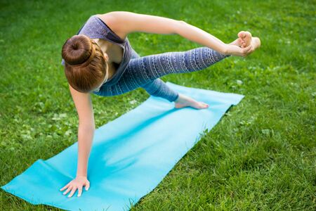 Young fitness woman meditation in a city park.Yoga at sunset in the park. Girl is practicing yoga. Fitness training outdoors. Attractive fitness woman. Workout outdoors. Healthy lifestyleの写真素材