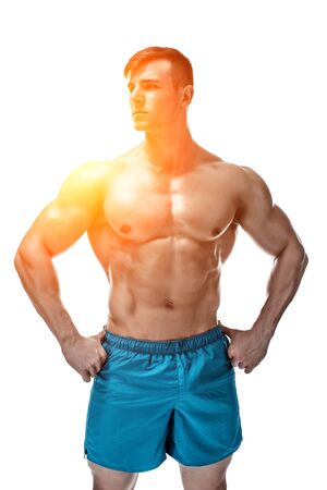Strong Athletic Man showing muscular body and sixpack abs isolated on white background. with sun flareの写真素材