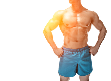 Strong Athletic Man showing muscular body and sixpack abs isolated on white background. with sun flareの写真素材