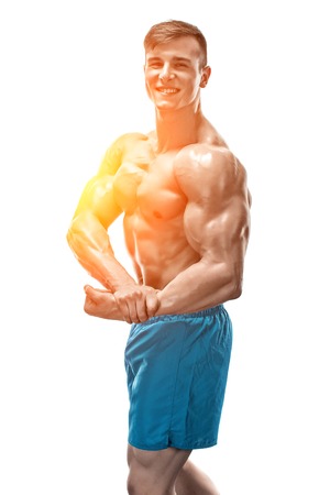 Strong Athletic Man showing muscular body and sixpack abs isolated on white background. with sun flareの写真素材