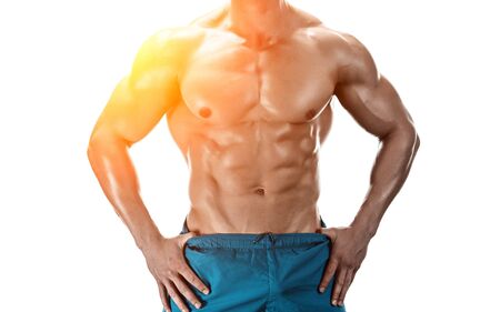 Strong Athletic Man showing muscular body and sixpack abs isolated white background. Close-up. with sun flareの写真素材